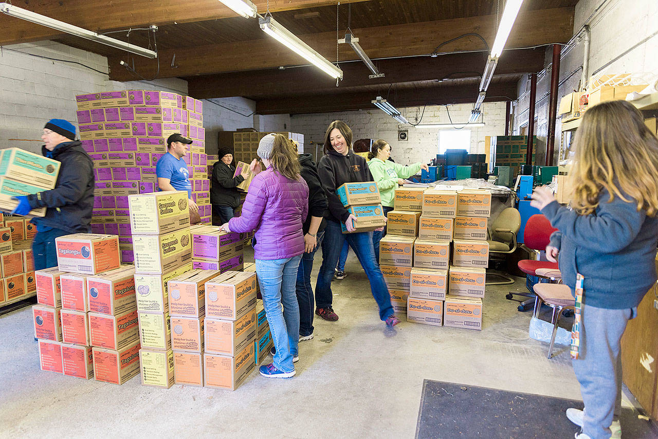 Photo by Anni Powell/Whidbey News-Times                                Jennifer Wilkins, at right, a Girl Scout leader and creative manager for Whidbey News Group, carries boxes of cookies during the local group’s distribution day. The Scouts utilized the Oak Harbor garage that was once home to the Whidbey News-Times’ printing press.