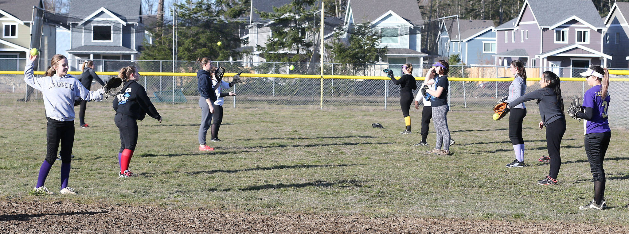 Members of the Oak Harbor High School softball team warm up for practice Thursday. (Photo by John Fisken)