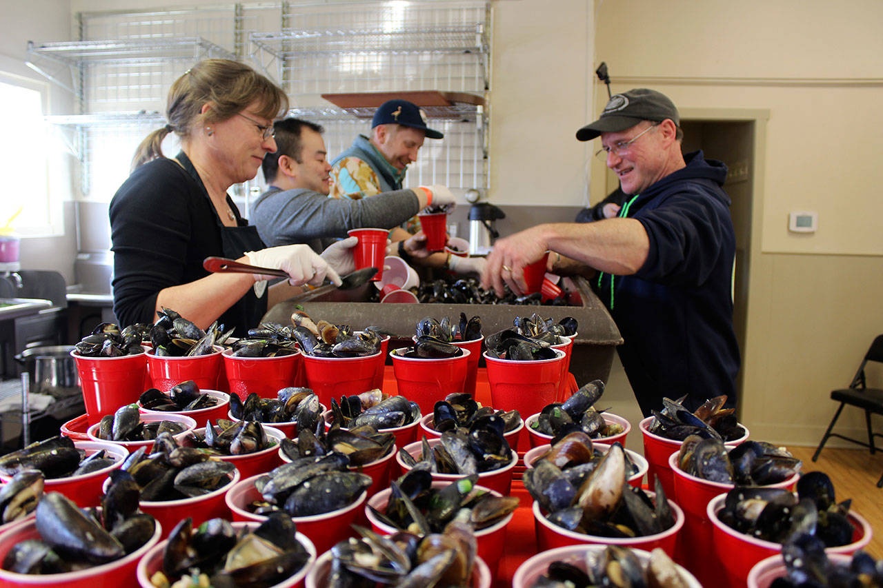 Laura and Rawl Jefferds of Penn Cove Shellfish help fill cups for the mussel-eating contest at the Coupeville Rec Hall. Photos by Patricia Guthrie/Whidbey News-Times