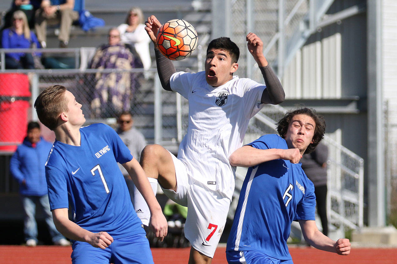 Coupeville’s Aram Leyva Elenes splits to Olympic players to gain control of the ball. (Photo by John Fisken)