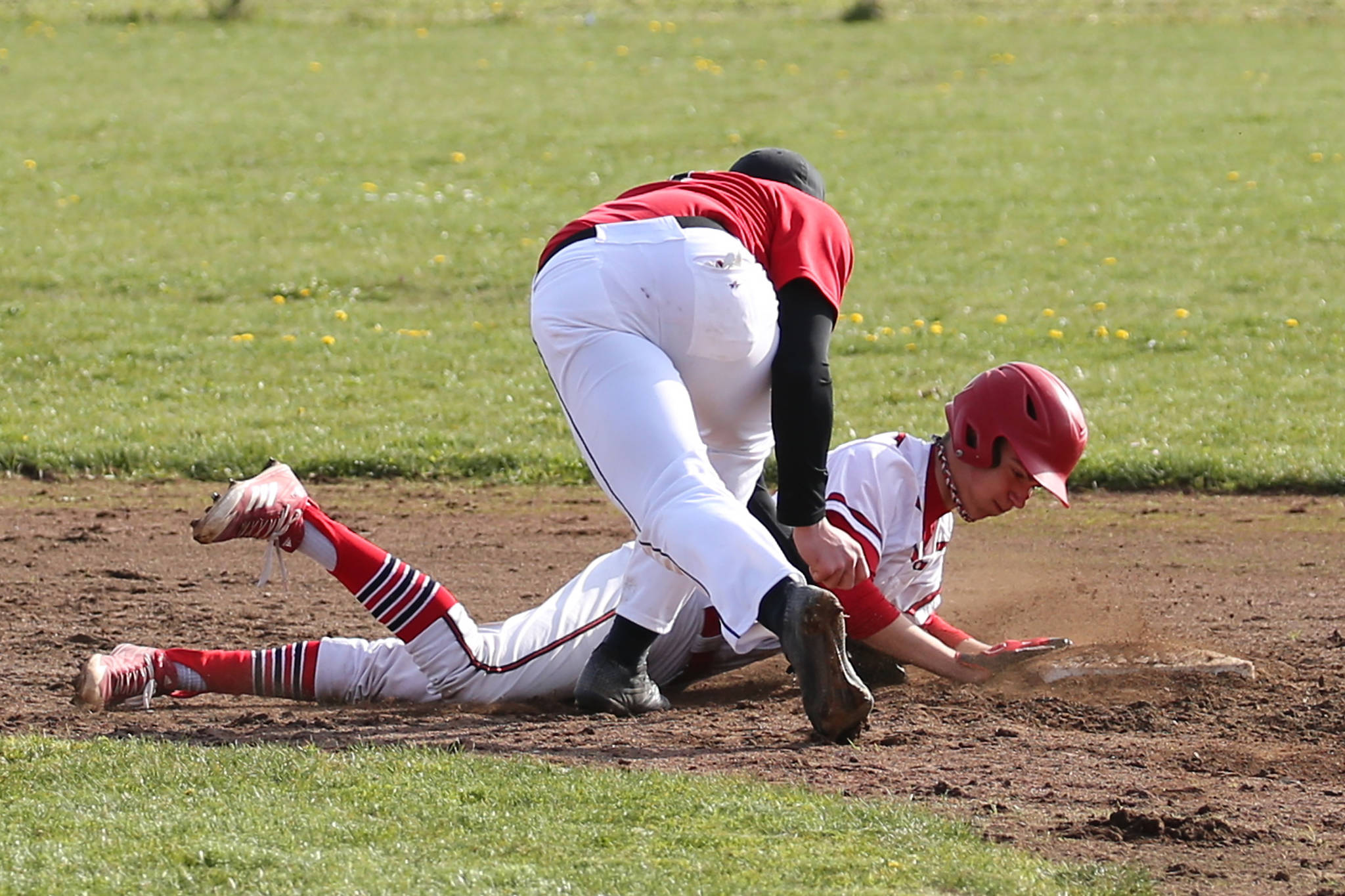Coupeville’s Nick Etzell dives safely back into second base after a Port Townsend pickoff attempt. (Photo by John Fisken)