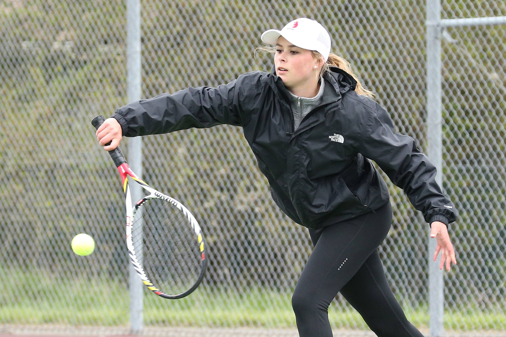 Payton Aparicio flips a shot over the net in her first doubles win against Chimacum Friday. (Photo by John Fisken)
