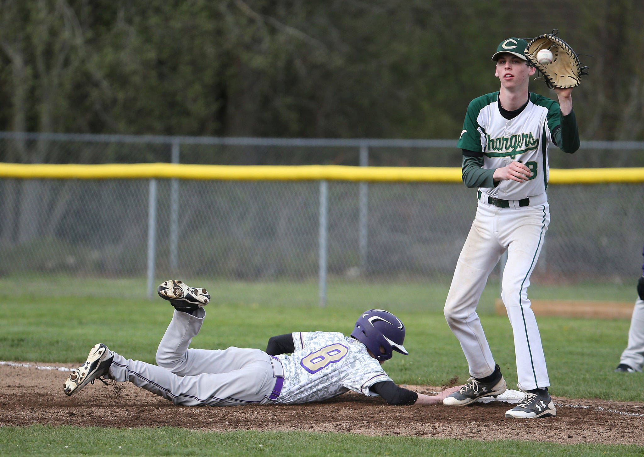 Noah Meffert slides safely back into first on a pickoff attempt as Marysville-Getchell’s Colten Bayley receives the throw.(Photo by John Fisken)