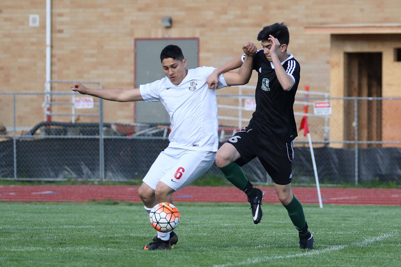 Coupeville’s Axel Partida, left, battles a Klahowya player for possession in Monday’s match. (Photo by John Fisken)