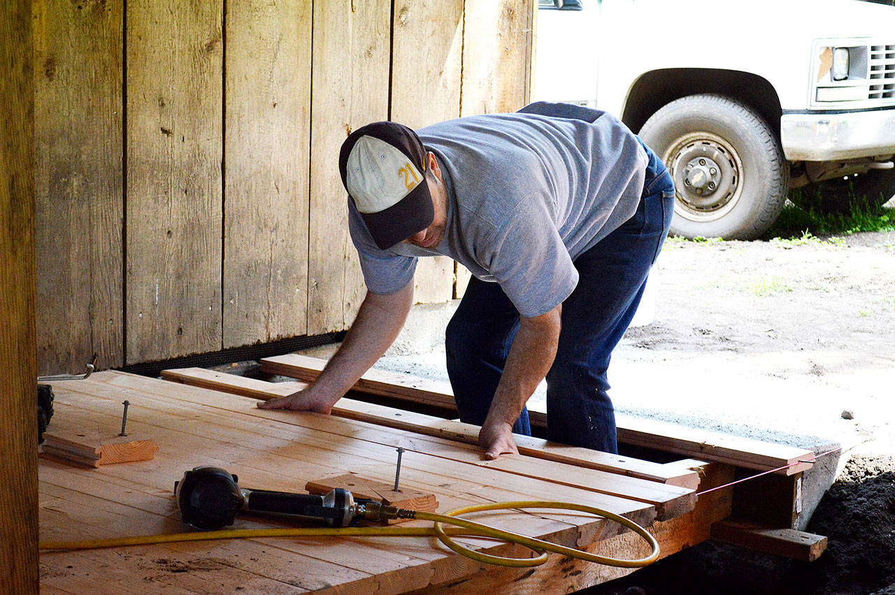 Scott Swenson, a National Park Service carpenter, puts the final pieces in on a ramp on the newly restored Pratt Sheep Barn. The 1930s barn will serve as a classroom one it officially opens in July. Photo by Laura Guido/Whidbey News Group