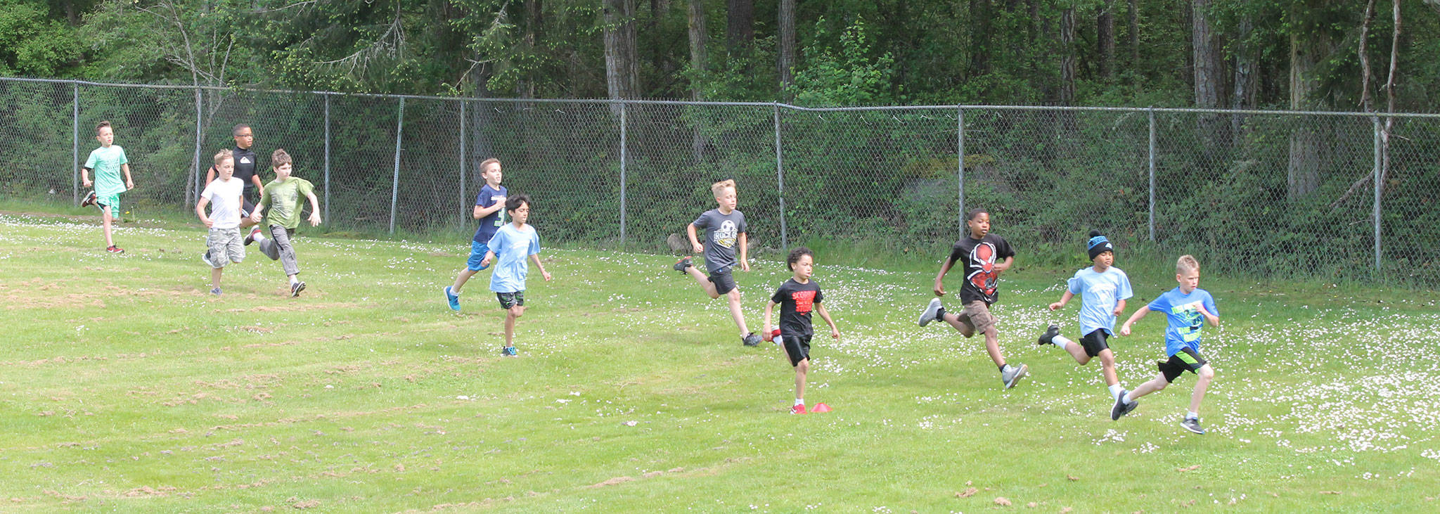 Boys stream across the field at Fort Nugent Park in an elementary school cross country meet May 17. (Photo by Jim Waller/Whidbey News-Times)