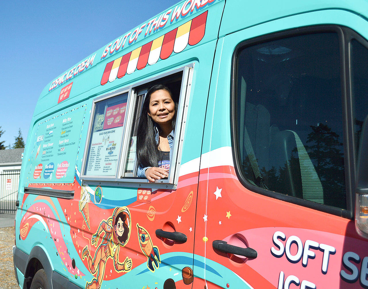 Glaiza Price, who owns and operates Cosmic Ice Cream with her husband Patrick, peeks out the van’s window. The space-themed van has started popping up at events this year to serve 24 flavors of soft serve ice cream. Photo by Laura Guido/Whidbey News-Times