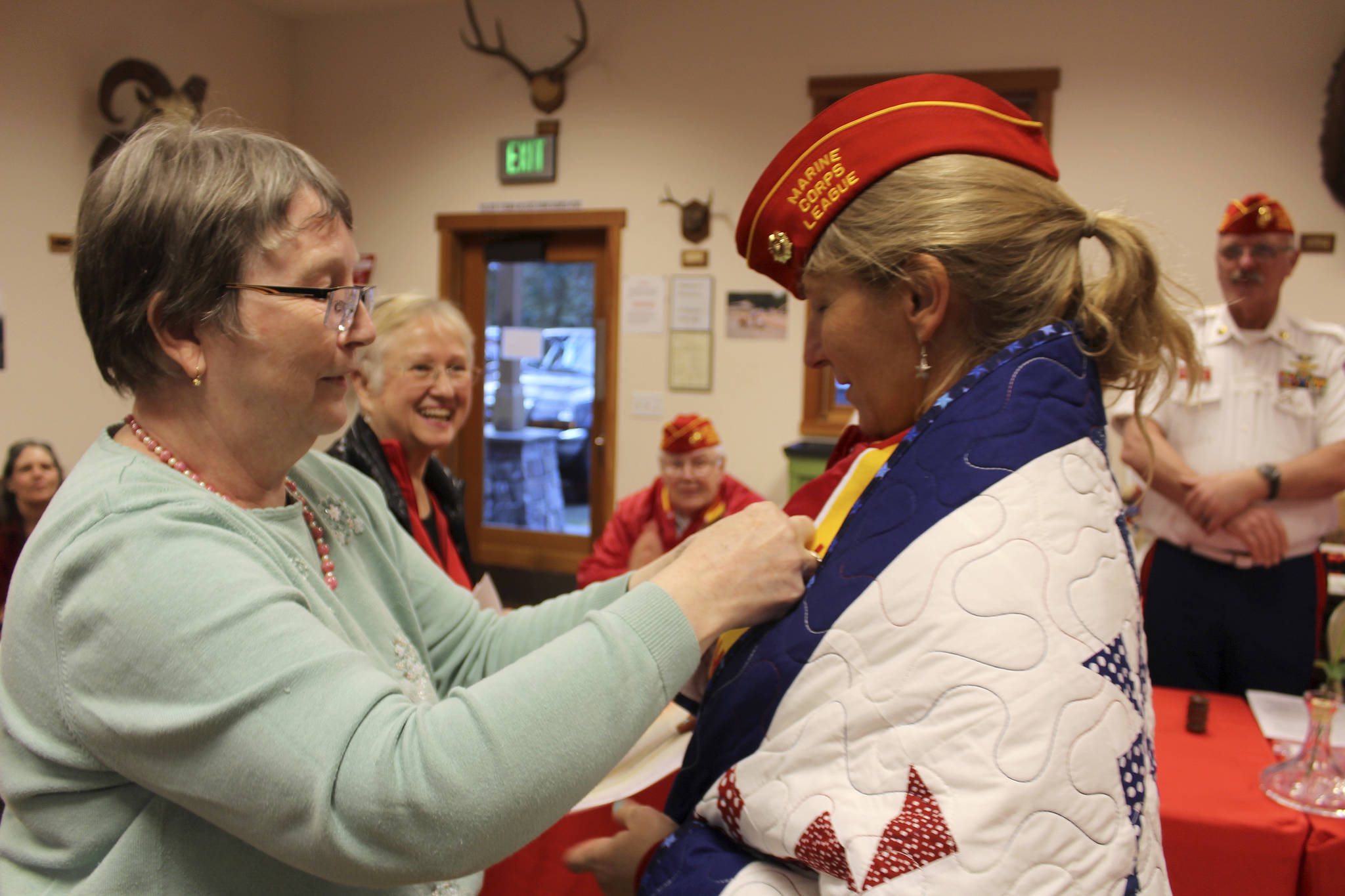 Anita Smith, founder of Quilts for Veterans, removes the name on the quilt after it was presented to “M.J.” Margaret Johns.
