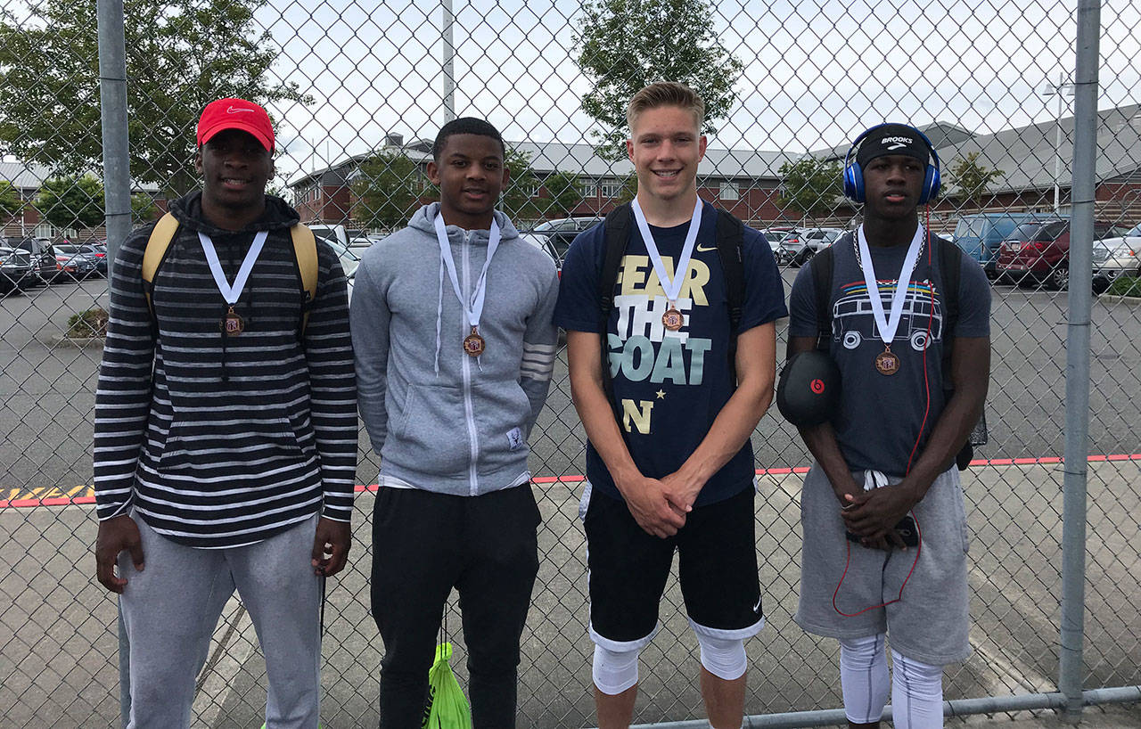 Oak Harbor High School’s 4x100 relay team of Taeson Hardin, left, Dorian Hardin, Andrew Miller and Jeff Gordon display their fourth-place medals. (Photo by Tracy Miller)