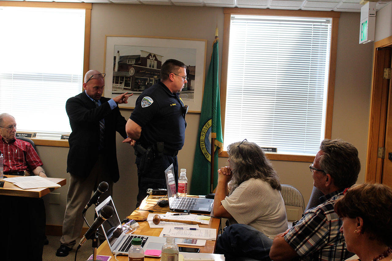 Consultant Glen Carpenter asked Langley Police Chief to help demonstrate handcuffing protocol and other arresting techniques during his 90-minute presentation of his use of force investigation into allegations against Marks. Photo by Patricia Guthrie/Whidbey News Group