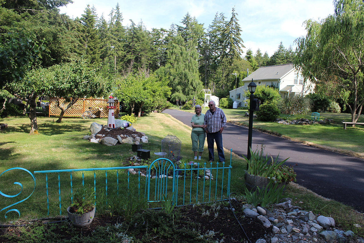 Mary and Fred Benninghoff in front of their 100-year-old home that served as an executive officer’s house and was moved from the Navy base in 1970. They created fences from old metal bed frames.Photo by Patricia Guthrie/Whidbey News Group