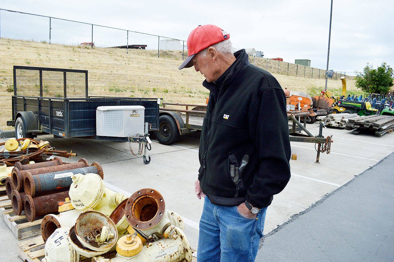 Auctioneer Harold Mather looks at old fire hydrants that will be sold for scrap metal Saturday during the Oak Harbor Citywide Auction. Viewing of the large inventory opens at 8 a.m., selling will start at 10 a.m. Photo by Laura Guido/Whidbey News-Times
