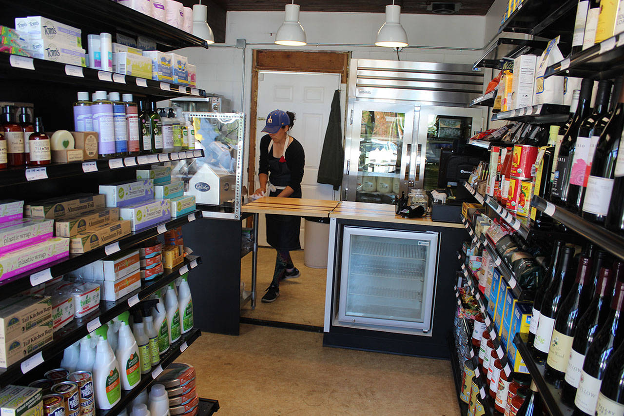 Emily Terao cleans up the small kitchen in the Greenbank Pantry and Deli that opened Thursday. It sells basic household items as well as wines, deli meats and cheeses, a variety of other food and freshly-made salads and sandwiches. Photo by Patricia Guthrie/Whidbey News Group