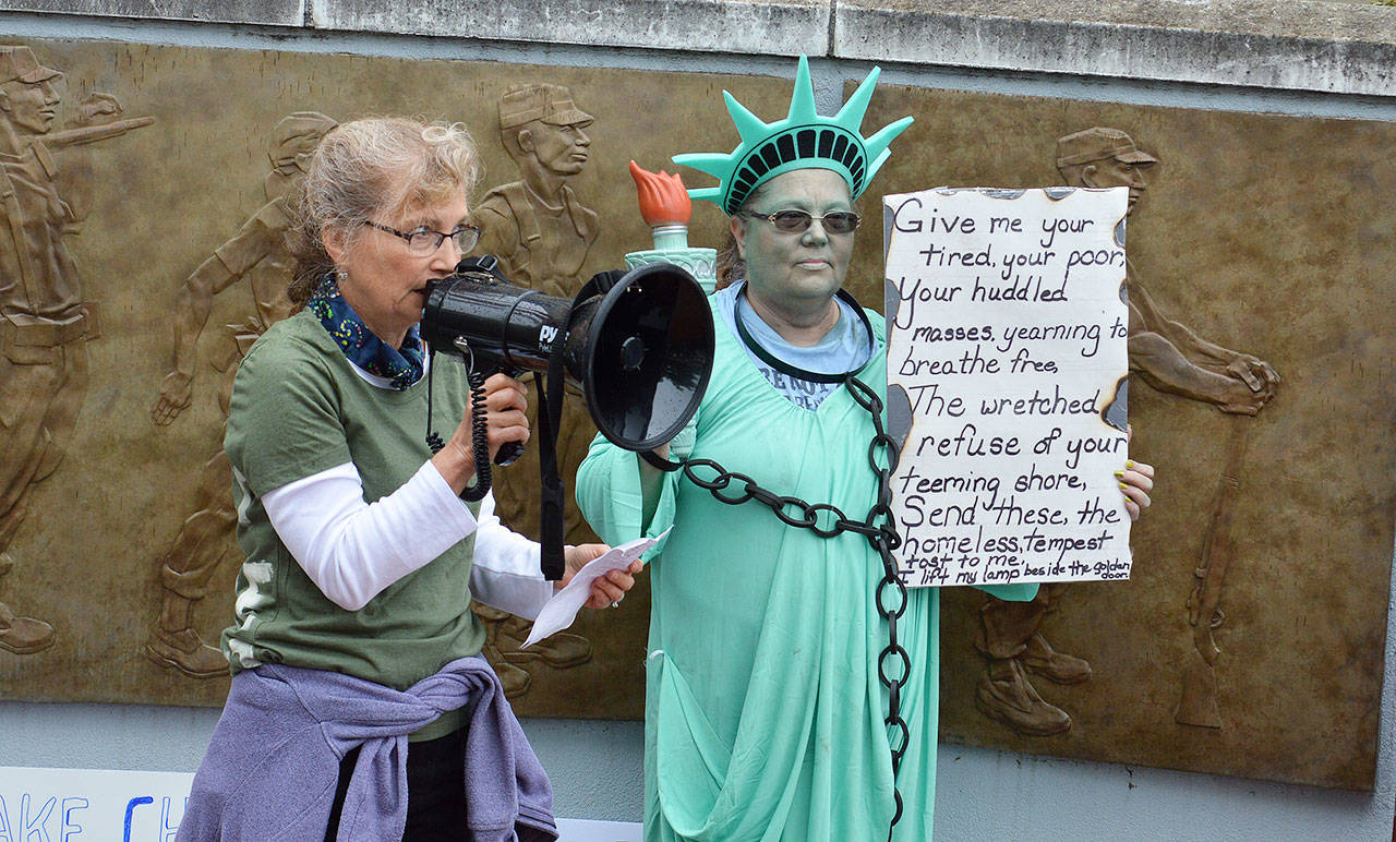 Rally organizers Linda Wehrman, left, and Pam Fick address a crowd of around 200 people Saturday morning at the Island County Veterans Memorial Plaza in Coupeville. The rally joined more than 700 others across the country to protest the separation of undocumented immigrant families. Photo by Laura Guido/Whidbey News-Times