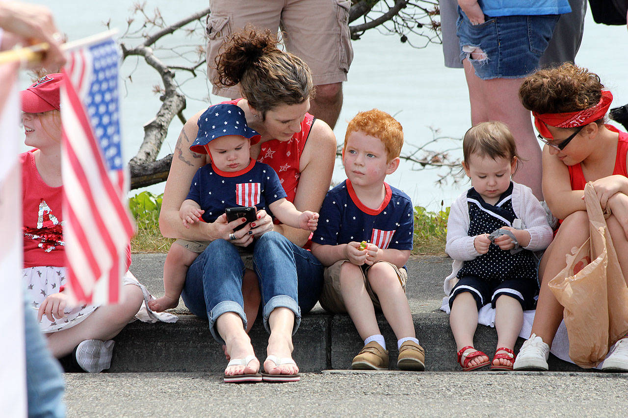 Photo by Jessie Stensland / Whidbey News-Times                                Erica Garcia sits next to her grandson, Grayson Jagger, 3, and holds Matthew Jagger, 8 months, during the parade. Charlotte Watson, 2, and Ella Allison, 9, sit nearby.