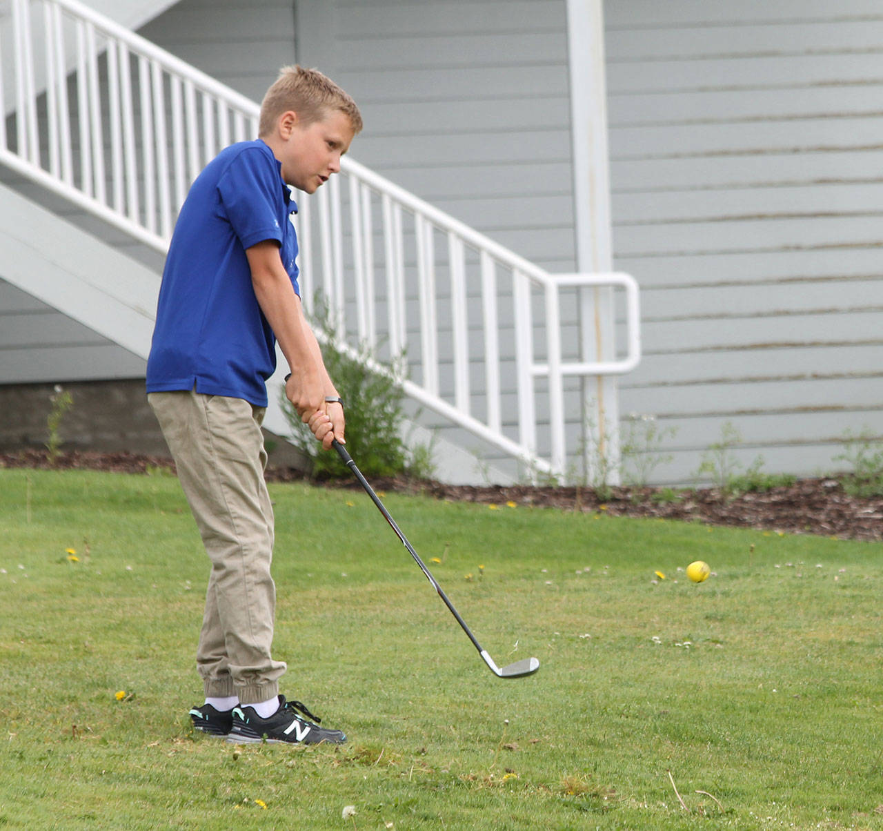 Nathan Hacket chips during Junior Golf Camp this week at the Whidbey Golf Club.(Photo by Jim Waller/Whidbey News-Times)