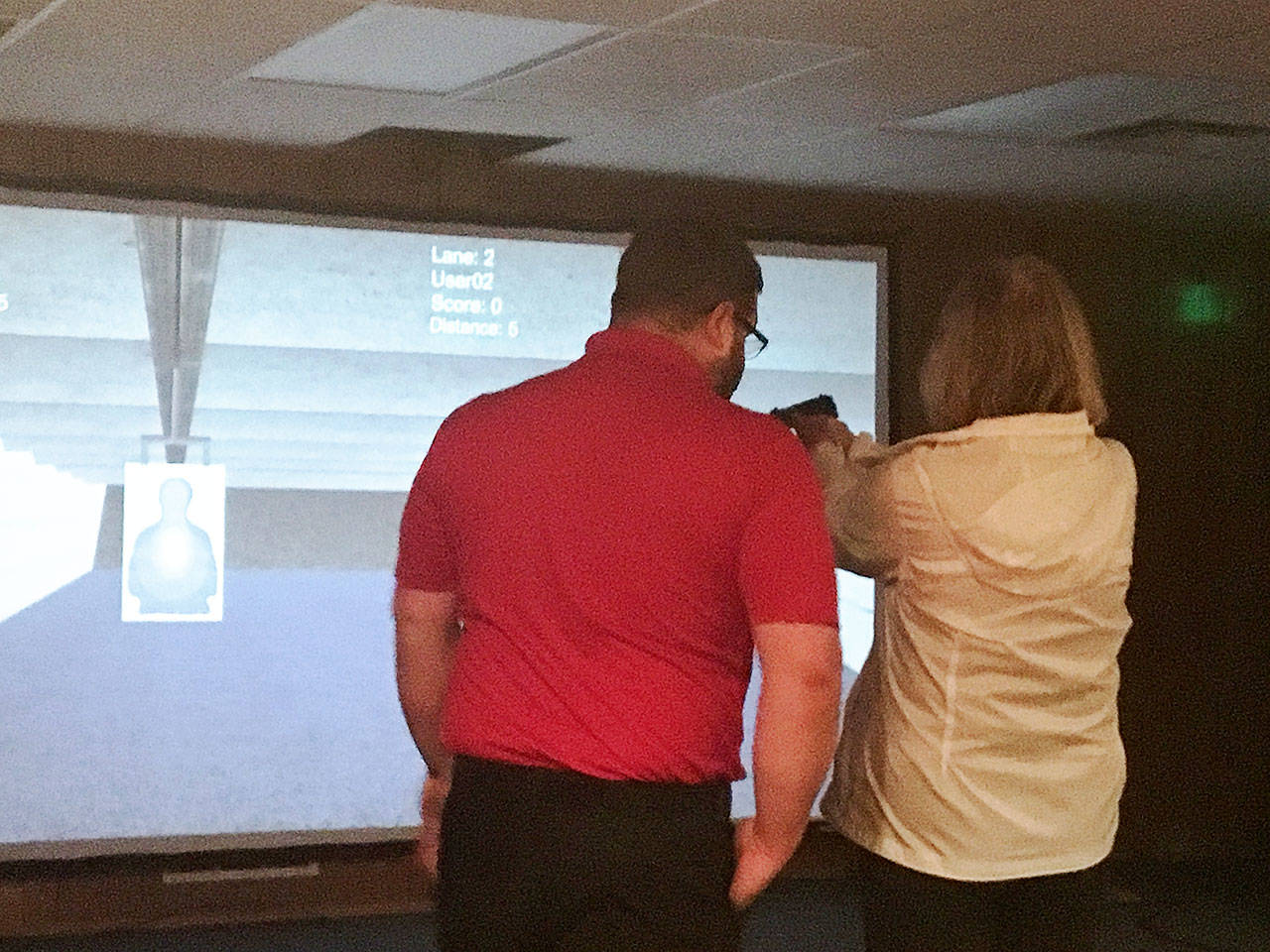 An Oak Harbor Police Department Citizens Advisory Board member uses a firearms training simulator. Participants of the free Citizens’ Academy held by the Oak Harbor Police Department will likely have the chance to use the simulator and do other police training during the program. Photo provided