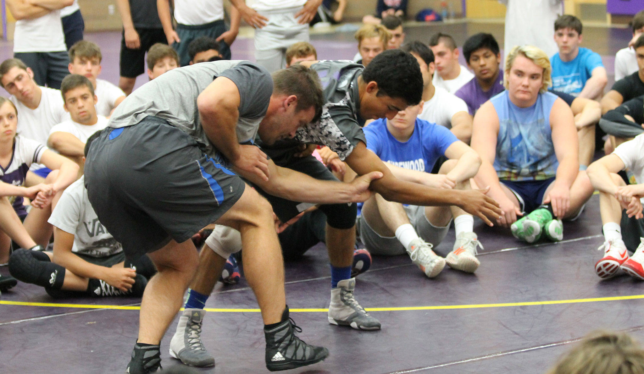 Oak Harbor’s Caleb Fitzgerald, right, helps counselor Jon Trenge display a move as the other campers look on. (Photo by Jim Waller/Whidbey News-Times)