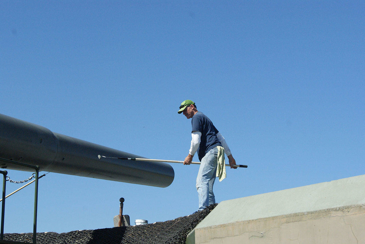 Photos by Maria Matson/Whidbey News-Times                                John White of Freeland works to paint the “Big Guns” at Fort Casey. It was a good day to paint, with the sunshine and fresh air, he said. The work is being done by volunteers in preparation for the 50th anniversary of the “Big Guns” arrival, which will be held on Aug. 11.