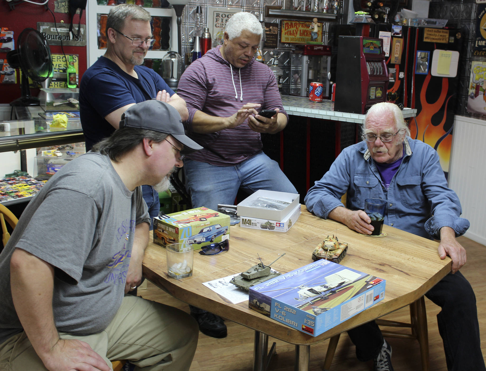 The Friday evening club of small-scale modelers discuss who’s building other tiny tanks needed for an upcoming contest. Left to right are Dave Campbell, Roy Schlicht, Ray Scott and Fred Benninghoff.