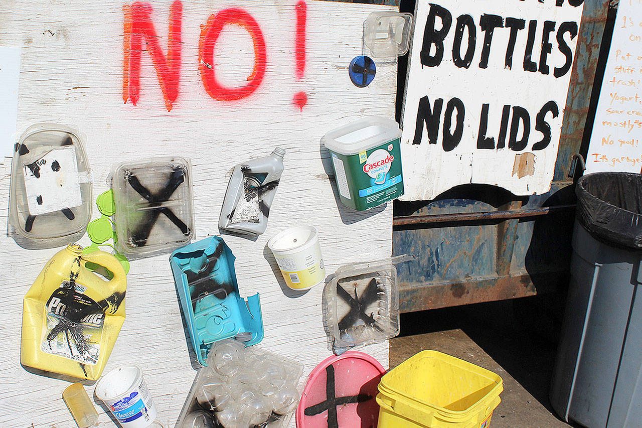 A board displays plastic containers refused at Island Recycling in Freeland. It takes containers marked with the recycling symbol No. and No. 2, which include water, juice and milk and other bottles.