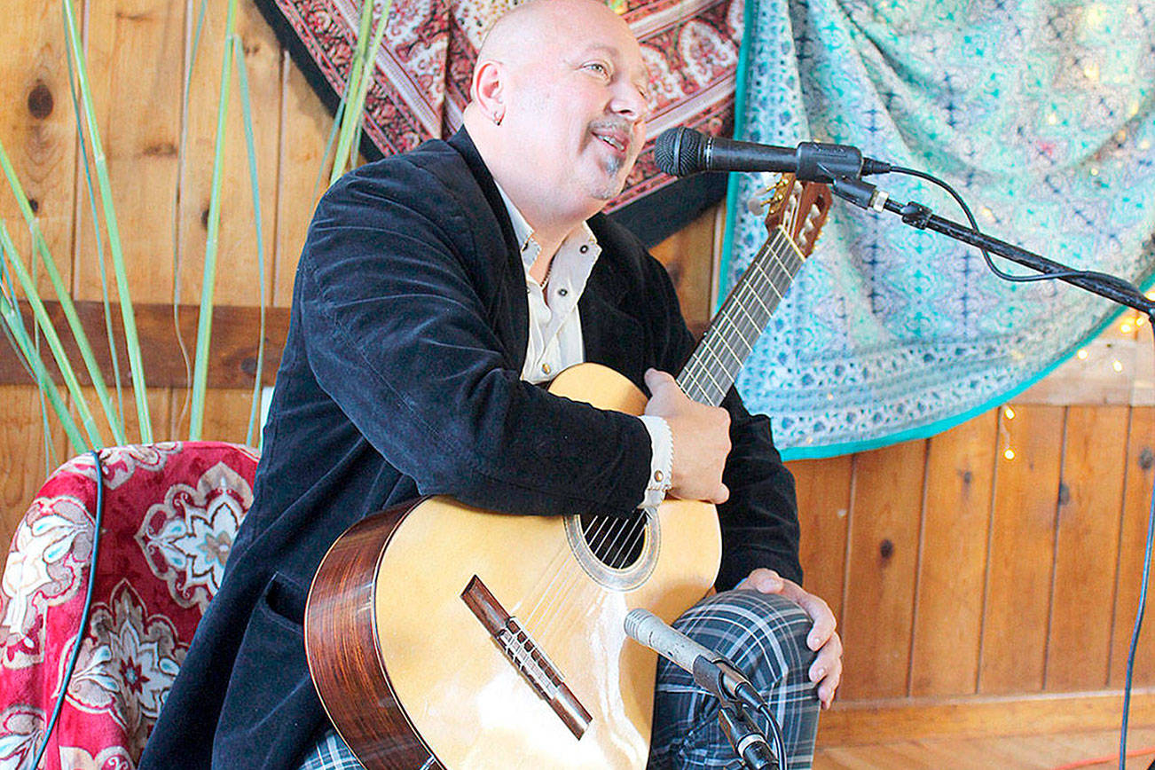 File photo/Whidbey News Group.                                Classical guitarist Andre Feriante of Langley plays at a gathering of Island Bohemians last year. He’s hosting a guitar festival at two South Whidbey wineries Aug. 10-12.