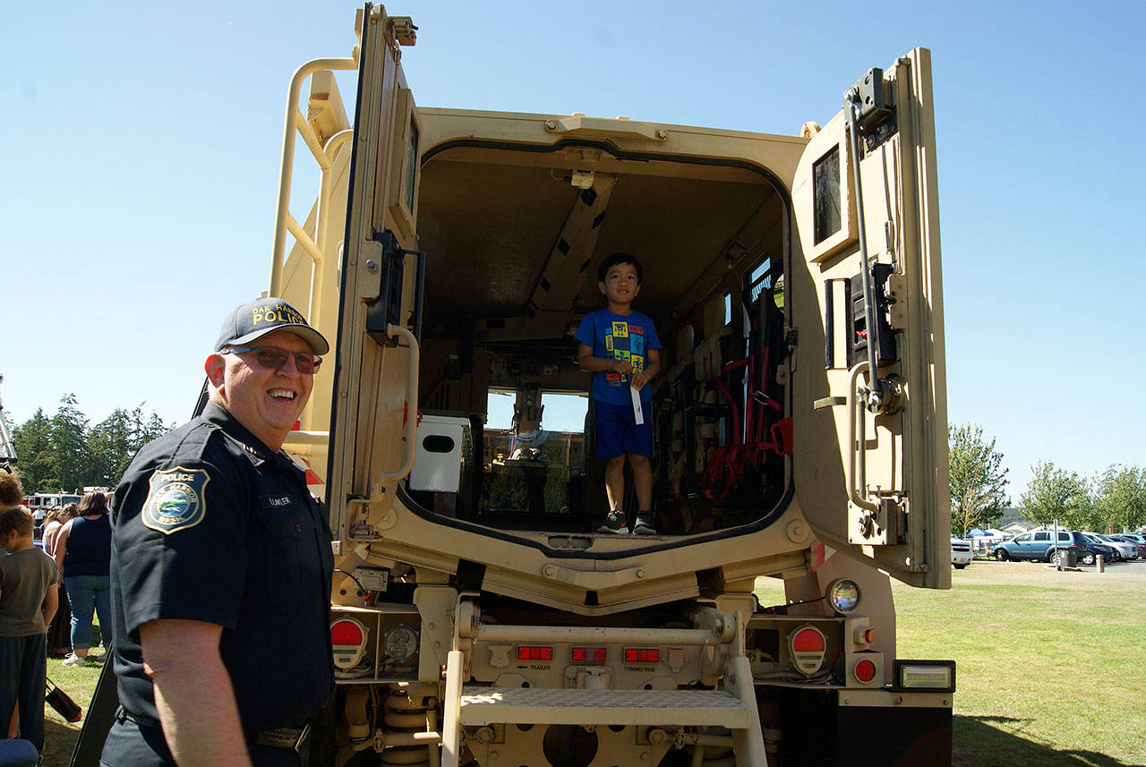 Photo by Maria Matson/Whidbey News-Times                                Four-year-old Atreyu Corpuz of Oak Harbor smiles as he stands inside a MRAP vehicle. Oak Harbor Police Department Chaplin Ron Lawler made sure he entered and exited the vehicle safely.