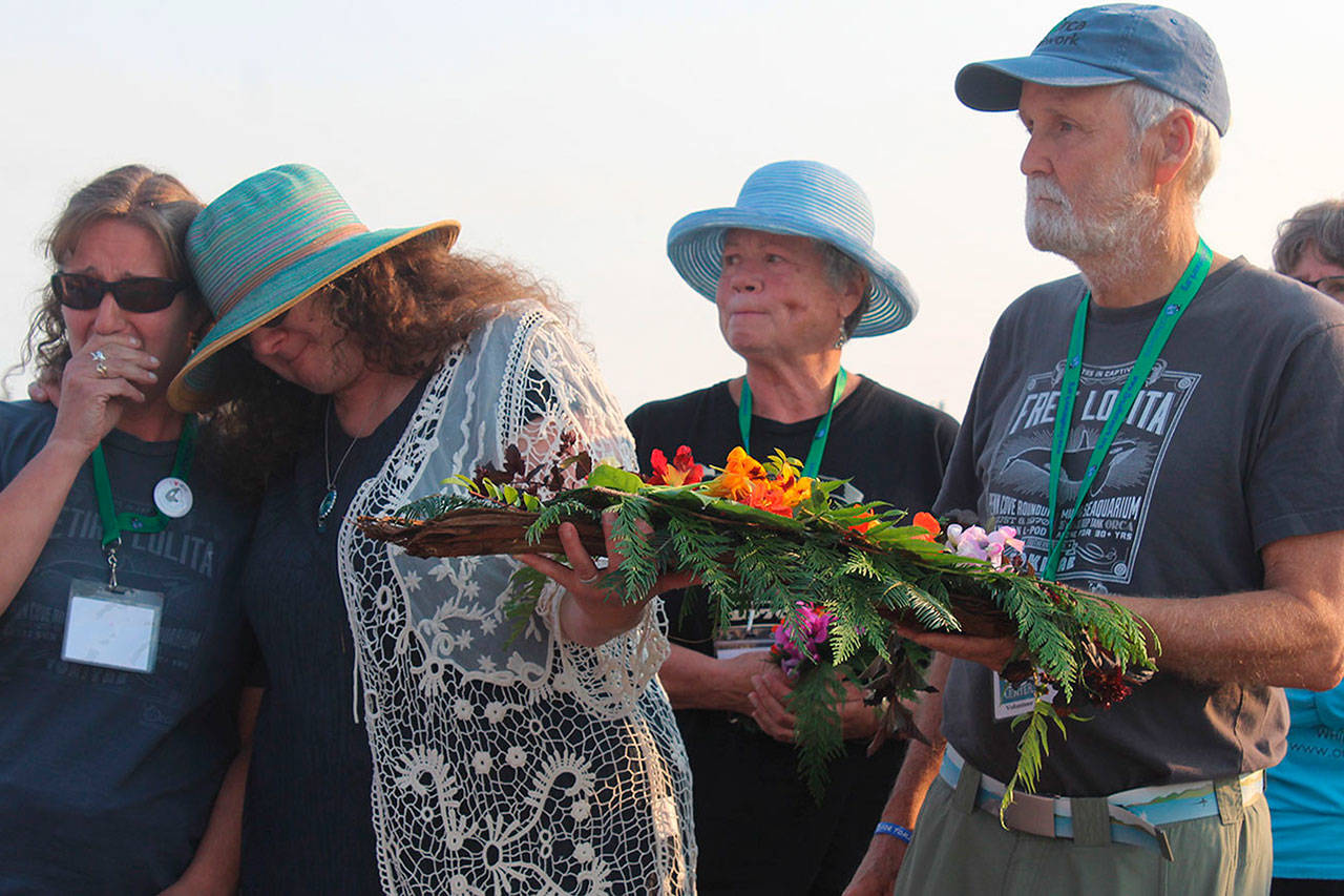 Honoring orcas captured in Penn Cove and the lone survivor, Tokitae, are Cindy Hansen, far left, Susan Berta, Jan Bell, center, and Howard Garrett. The annual ceremony was held Wednesday at the Coupeville Wharf. (Photo by Patricia Guthrie/Whidbey News-Group)