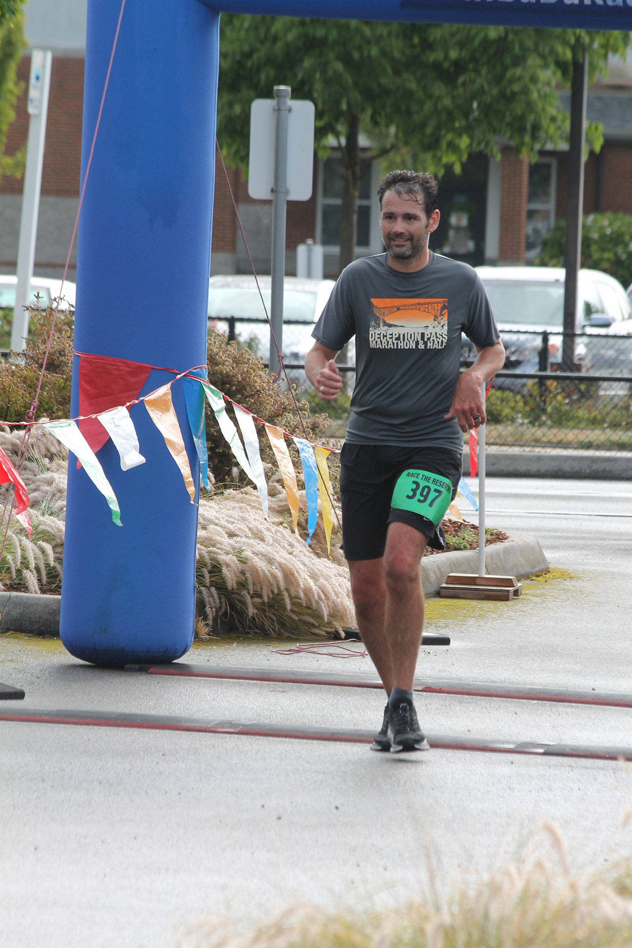 Coupeville’s James Steller crosses the finish line of the half marathon during the running of the Race the Reserve Saturday. (Photo by Jim Waller/Whidbey News-Times)