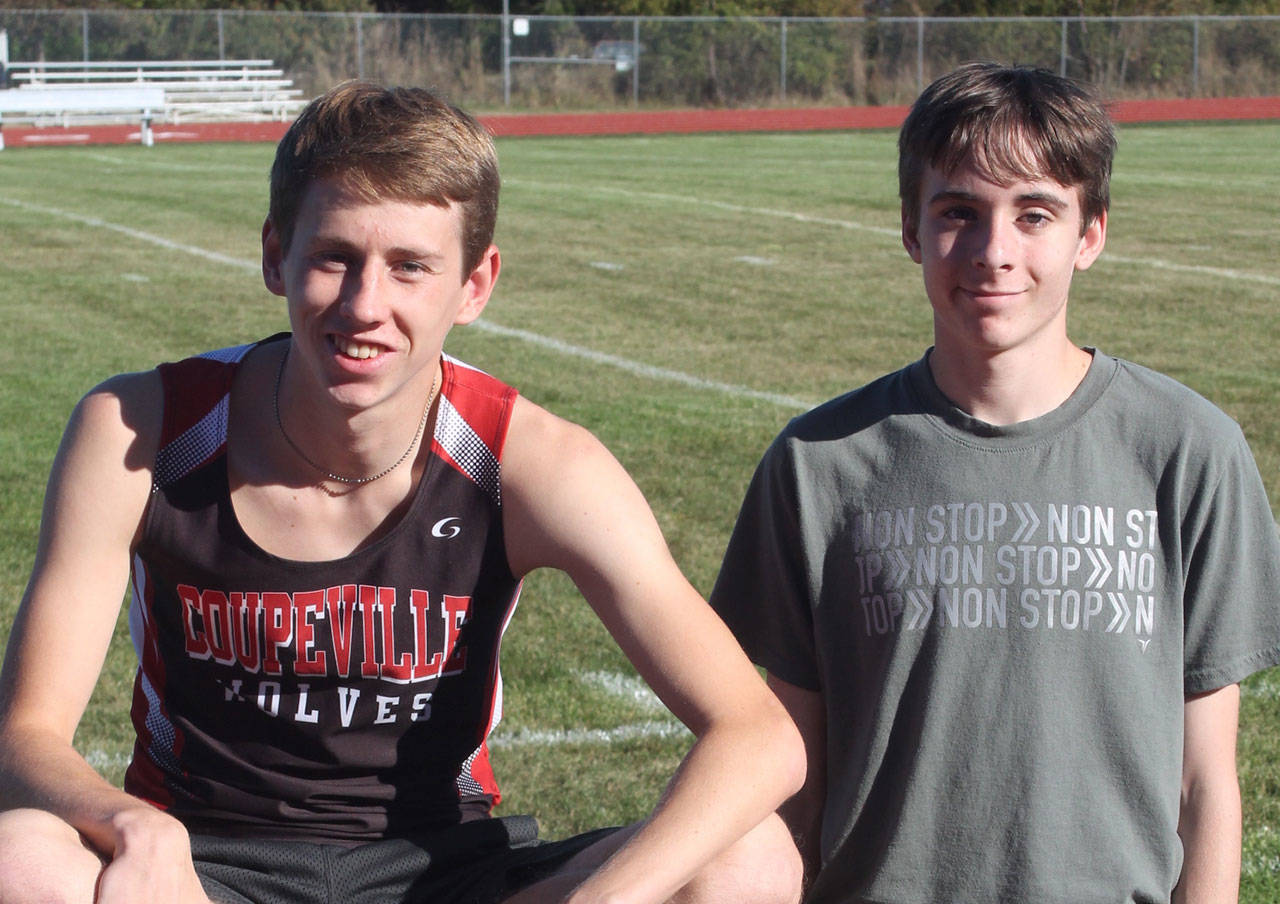 Henry Wynn, left, and Danny Conlisk take a break during a cross country workout in 2016. The pair ignited a renewed interested in the sport at Coupeville High School. (Photo by Jim Waller/Whidbey News-Times)
