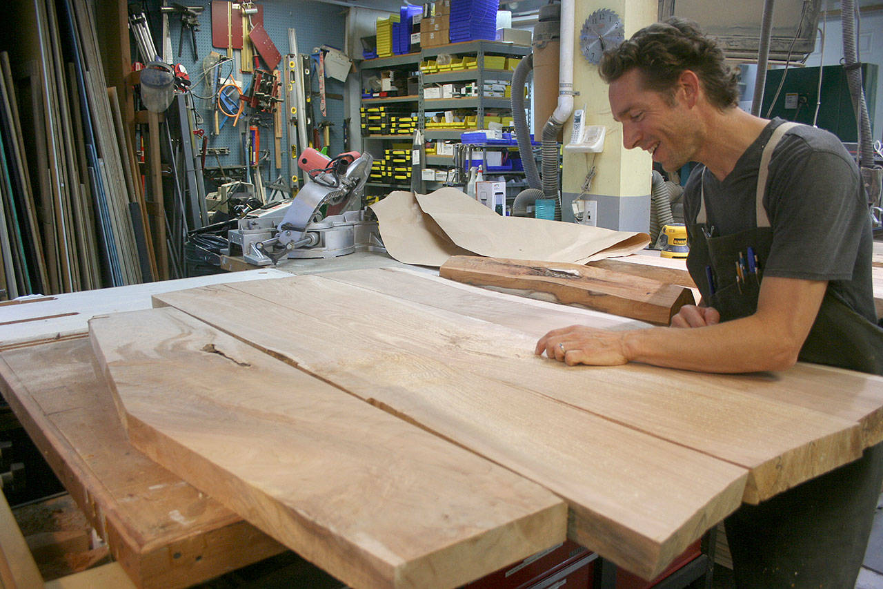 Photo by Emily Gilbert / Whidbey News-Times                                Glen Pearson inspects the Maple wood slabs that will become the top of the table he’s making for Woodpalooza this year. He said it’ll take him about 60 hours to have the table finished.