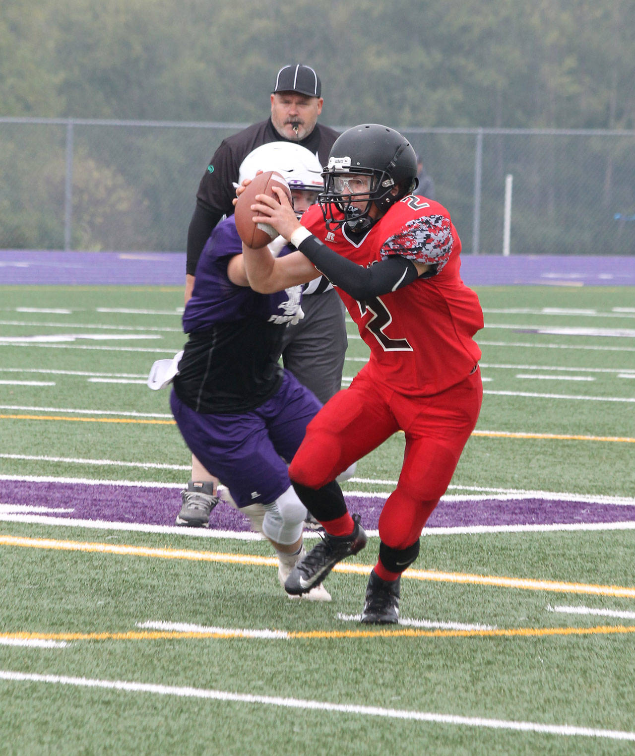 Coupeville quarterback Dawson Houston escapes an Anacortes defender in Saturday’s jamboree. (Photo by Jim Waller/Whidbey News-Times)