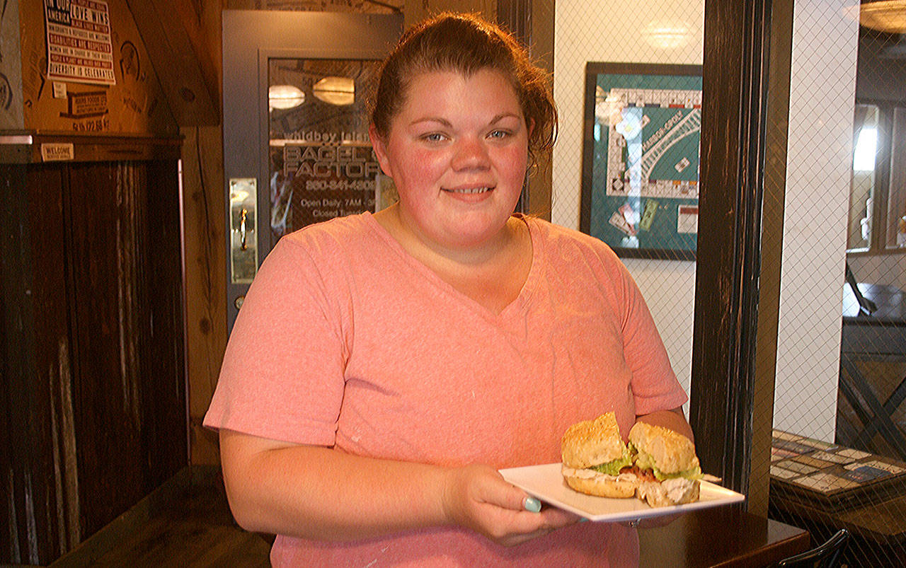 Oak Harbor store manager Michelle Berger holds the location’s best seller, the Turkey Club. She came up from the Clinton location to manage the new store when it opened in April. Photo by Emily Gilbert/Whidbey News Group.
