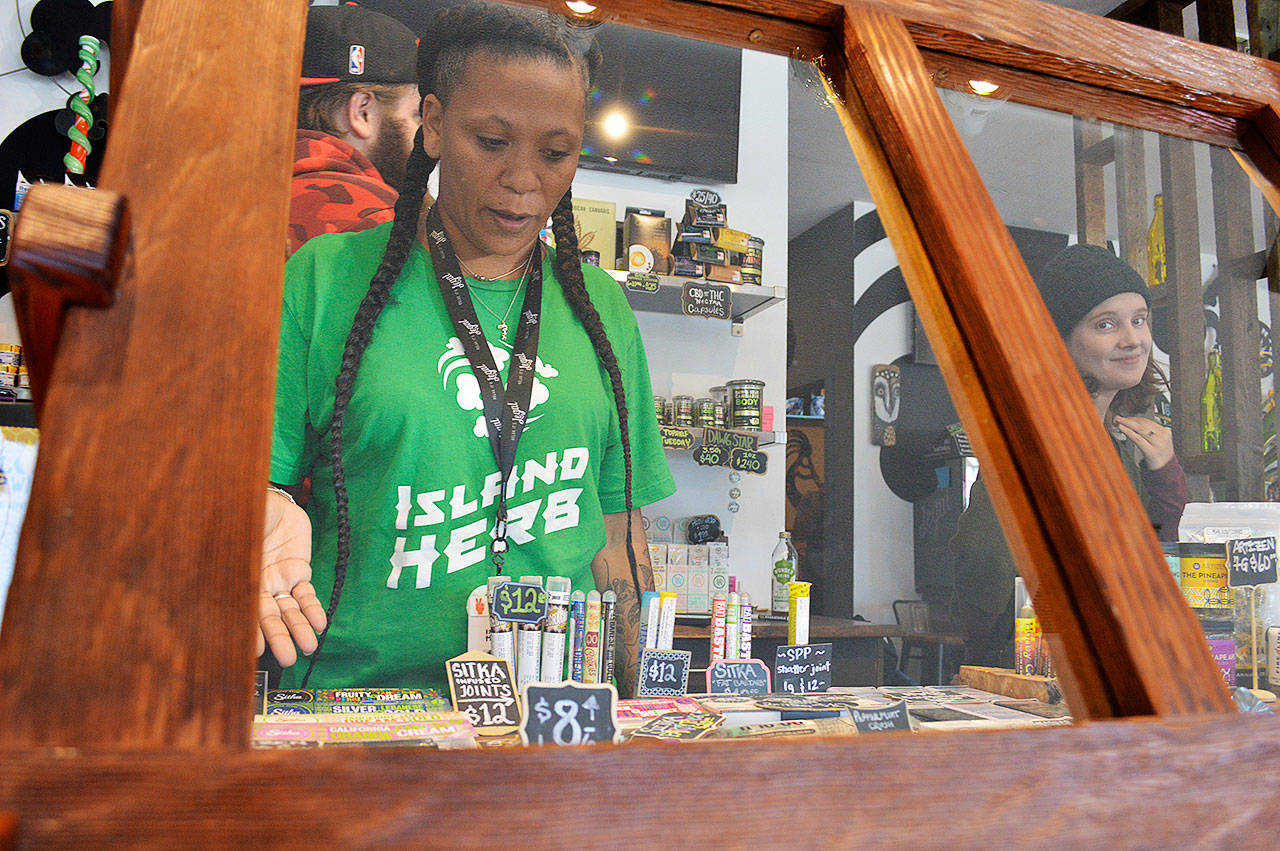 Valerie Boothe points out some of Island Herb’s products, which include the pre-rolled joints in the display case in front of her. Photo by Laura Guido/Whidbey News Group