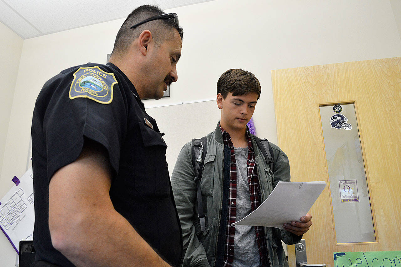 Officer Jim Hoagland answers questions from Oak Harbor High School junior Andrew Löff about joining the police department’s Community Advisory Board. Photo by Laura Guido/Whidbey News-Times