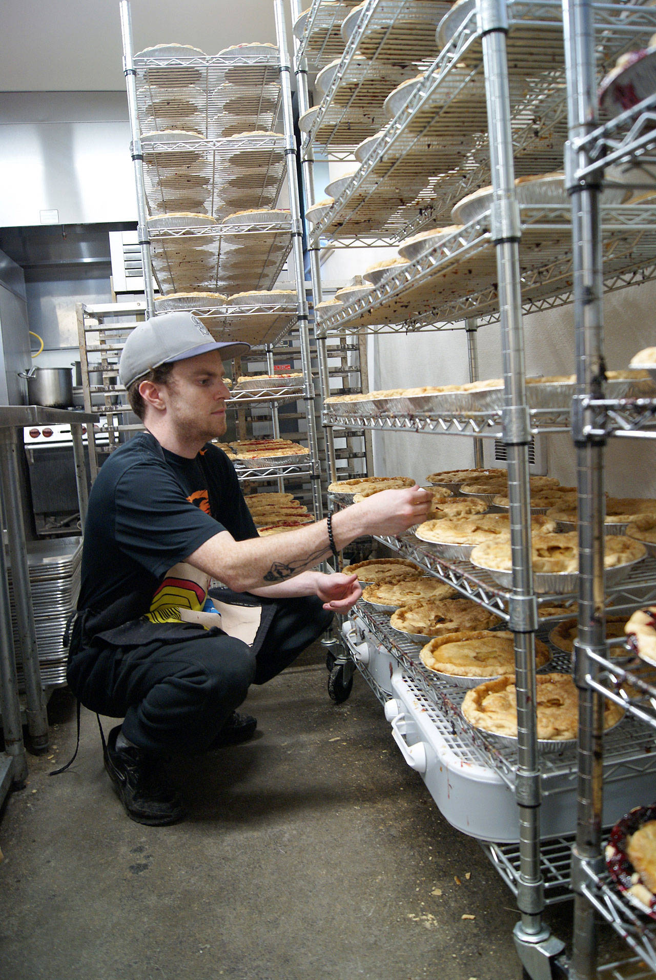 Photo by Maria Matson/Whidbey News-Times.                                Jordan Henriot checks the temperature on individual pies, ensuring that they cool to the proper temperature.