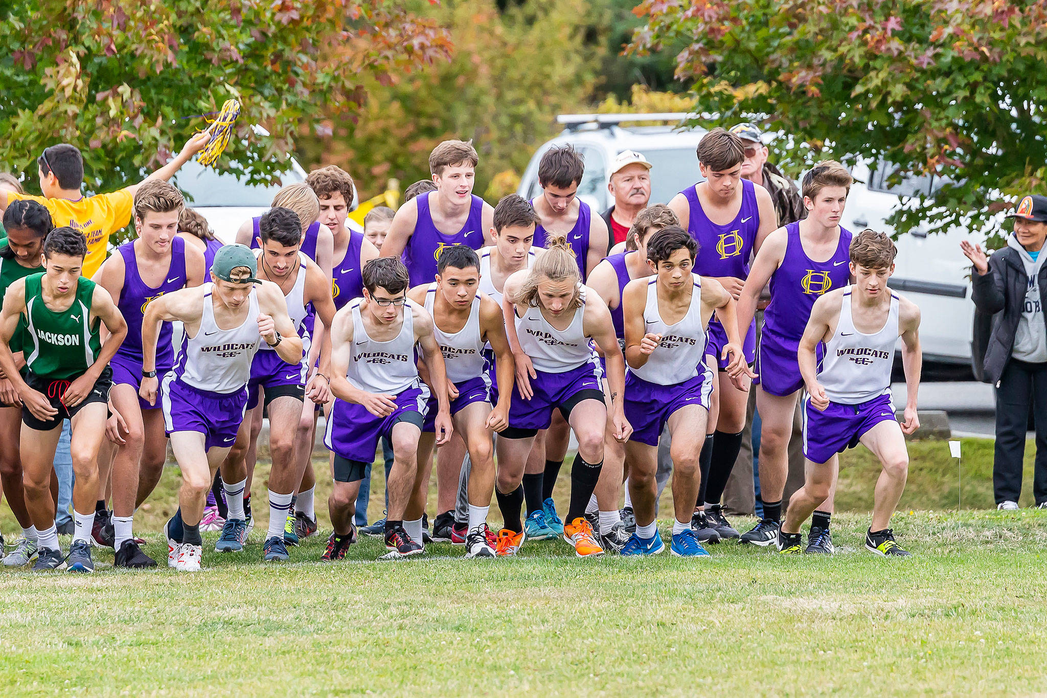 The Oak Harbor boys take off at the beginning of Thursday’s race. Dallas Riddle-Stevens, far left in the cap, finished first out of 64 runners. (Photo by John Fisken)
