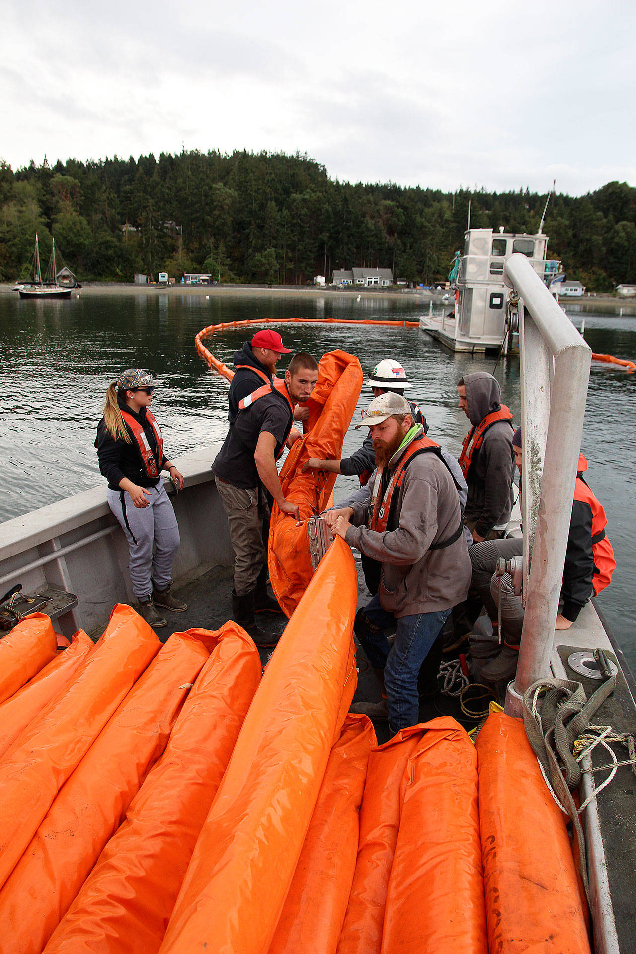 From left, Natalie Wagoner, Jay Dassow, Jeremiah Tumulty and Brandon Andrews help National Response Corporation deckhand Tyler Millius retrieve an oil boom during a training exercise last Friday afternoon. Photo by Laura Guido/Whidbey News-Times