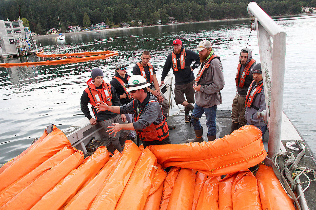 Penn Cove Shellfish employees Reanna Johnson, left, Natalie Wagoner, Jeremiah Tumulty, Jay Dassow, Brandon Andrews, Chris Knowles and Juan Gasper listen to Tyler Millius, a deckhand with National Response Corporation. Photo by Laura Guido/Whidbey News-Times