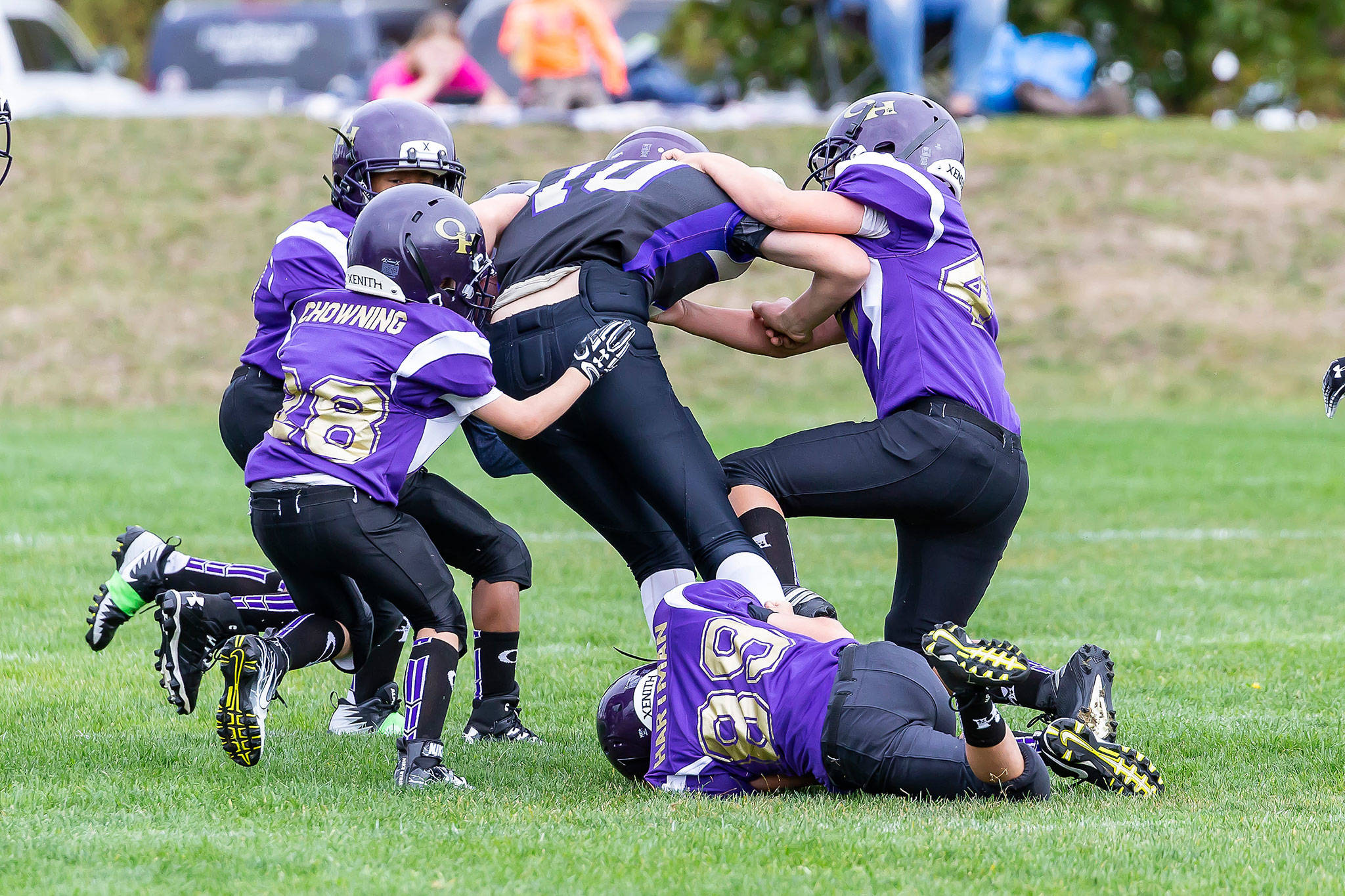 Oak Harbor players gang tackle an opponent in one of Saturday’s youth football games. (Photos by John Fisken)