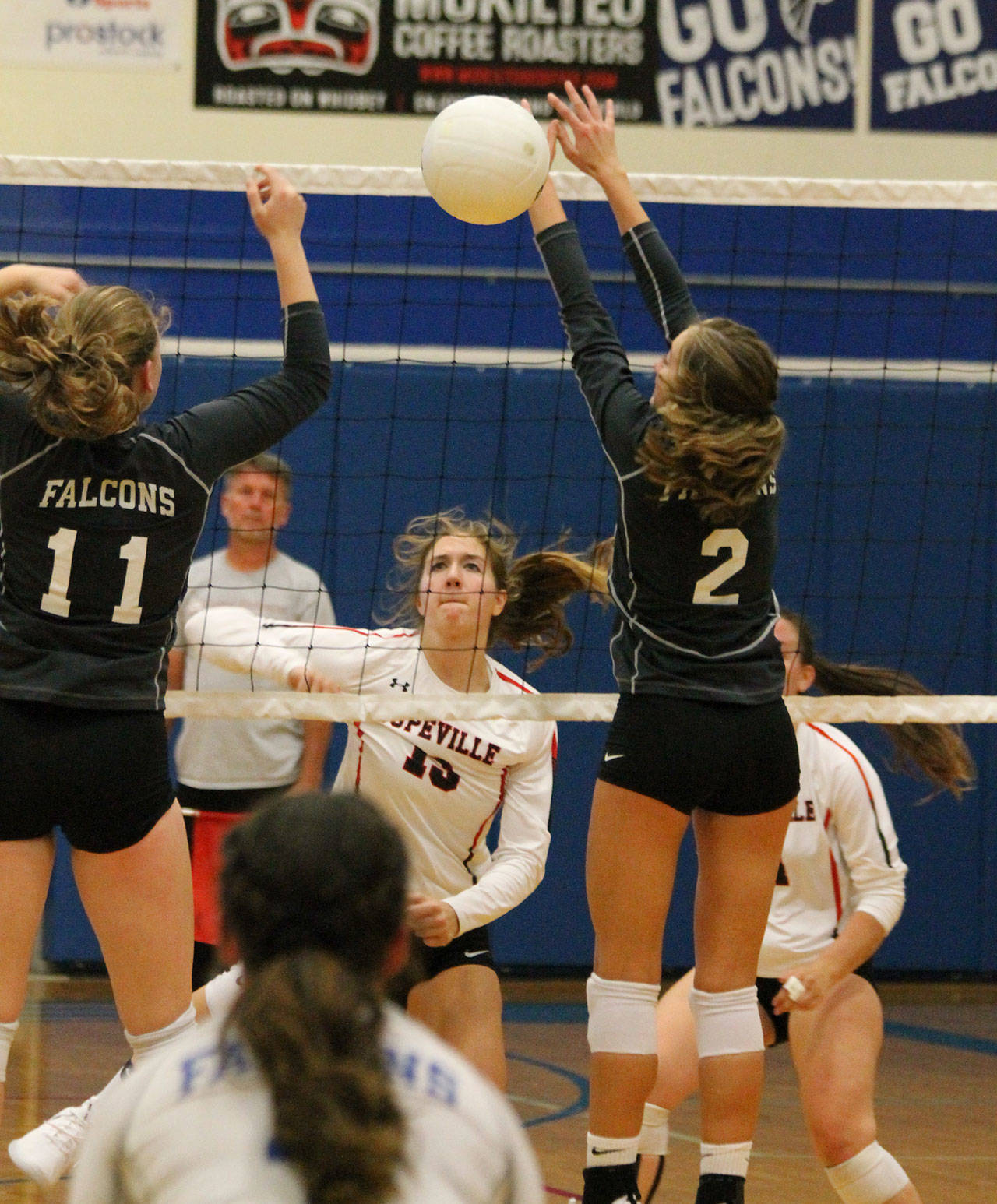 Emma Smith, center, watches her hit split the block of South Whidbey’s Emma Hodson (11) and Alyssa Ludtke (2).(Photo by Jim Waller/Whidbey News-Times)