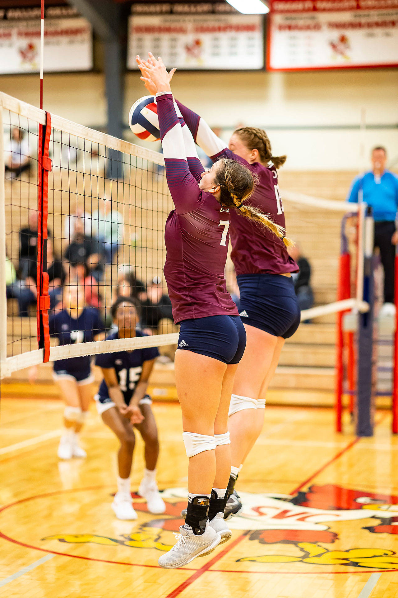 Samantha Hines, front, and Hailee Blau team-up for a block in Whatcom’s match Wednesday. (Photo by John Fisken)
