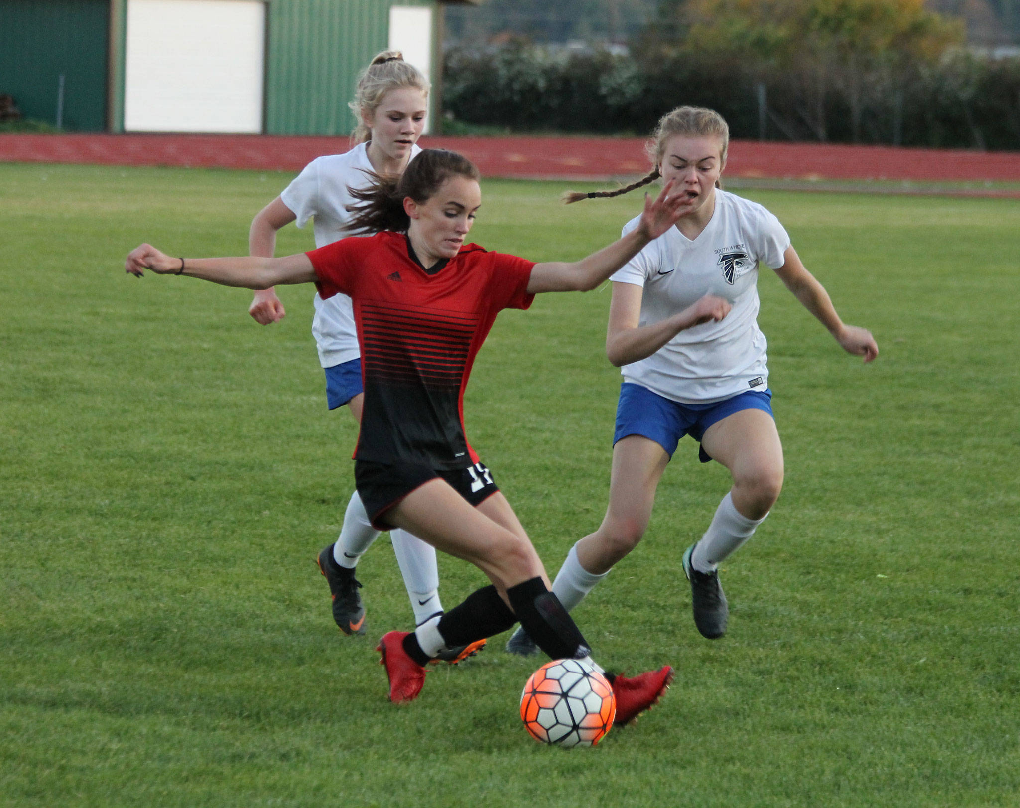 Coupevilles Mallory Kortuem beats two Falcons to the ball in Mondays match.(Photo by Jim Waller/Whidbey News-Times)