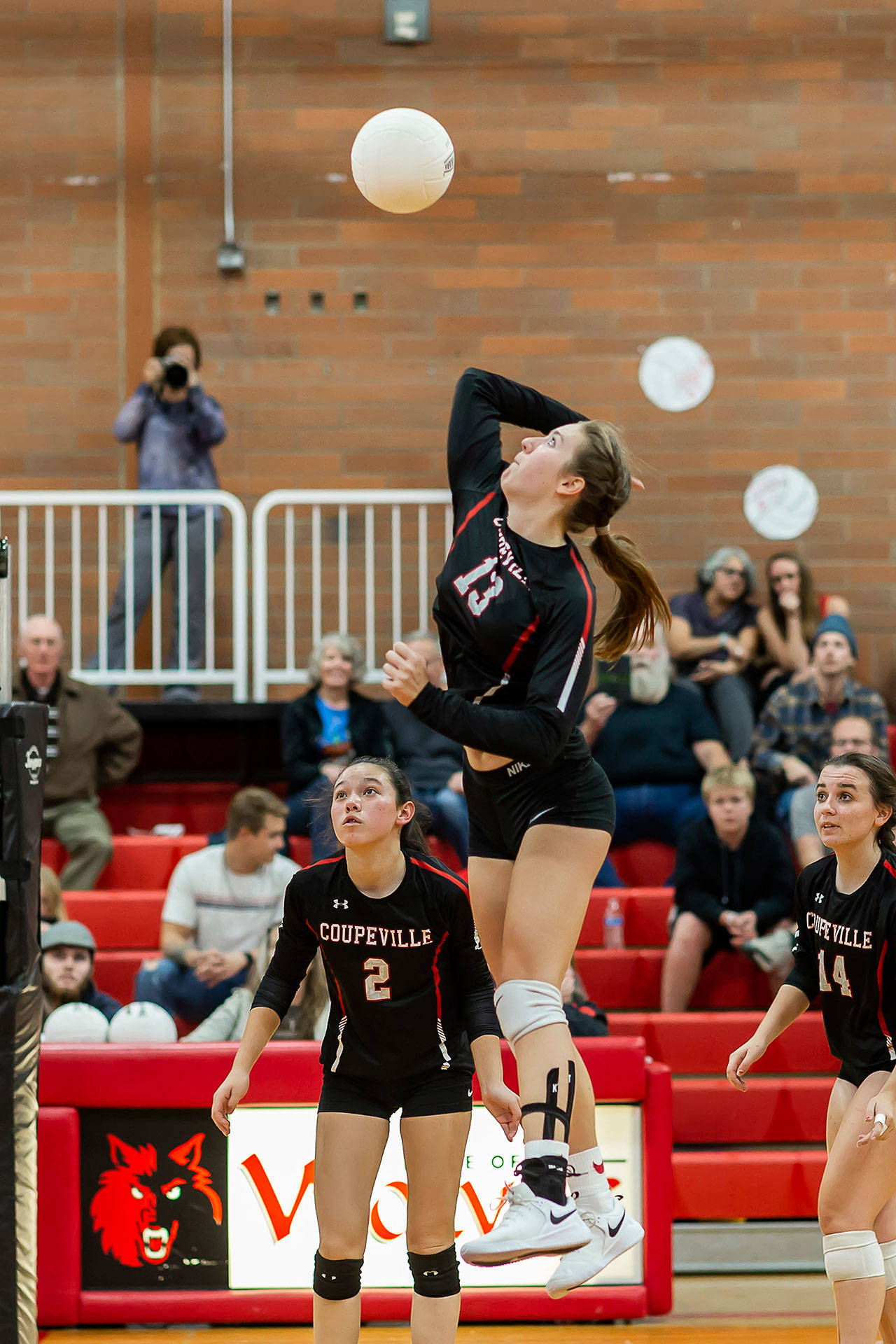 Emma Smith hits against Sultan as Scout Smith (2) and Ashley Menges (14) look on.(Photo by John Fisken)