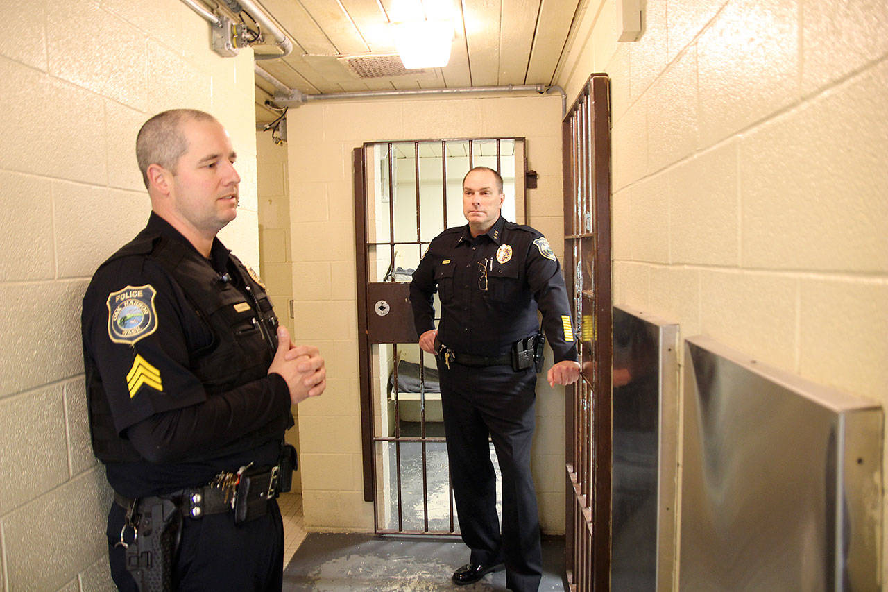 Photo by Jessie Stensland / Whidbey News-Times                                Brian Braunstein, the jail sergeant, and Oak Harbor Police Chief Kevin Dresker, at right, talk in the cramped space of the city jail.