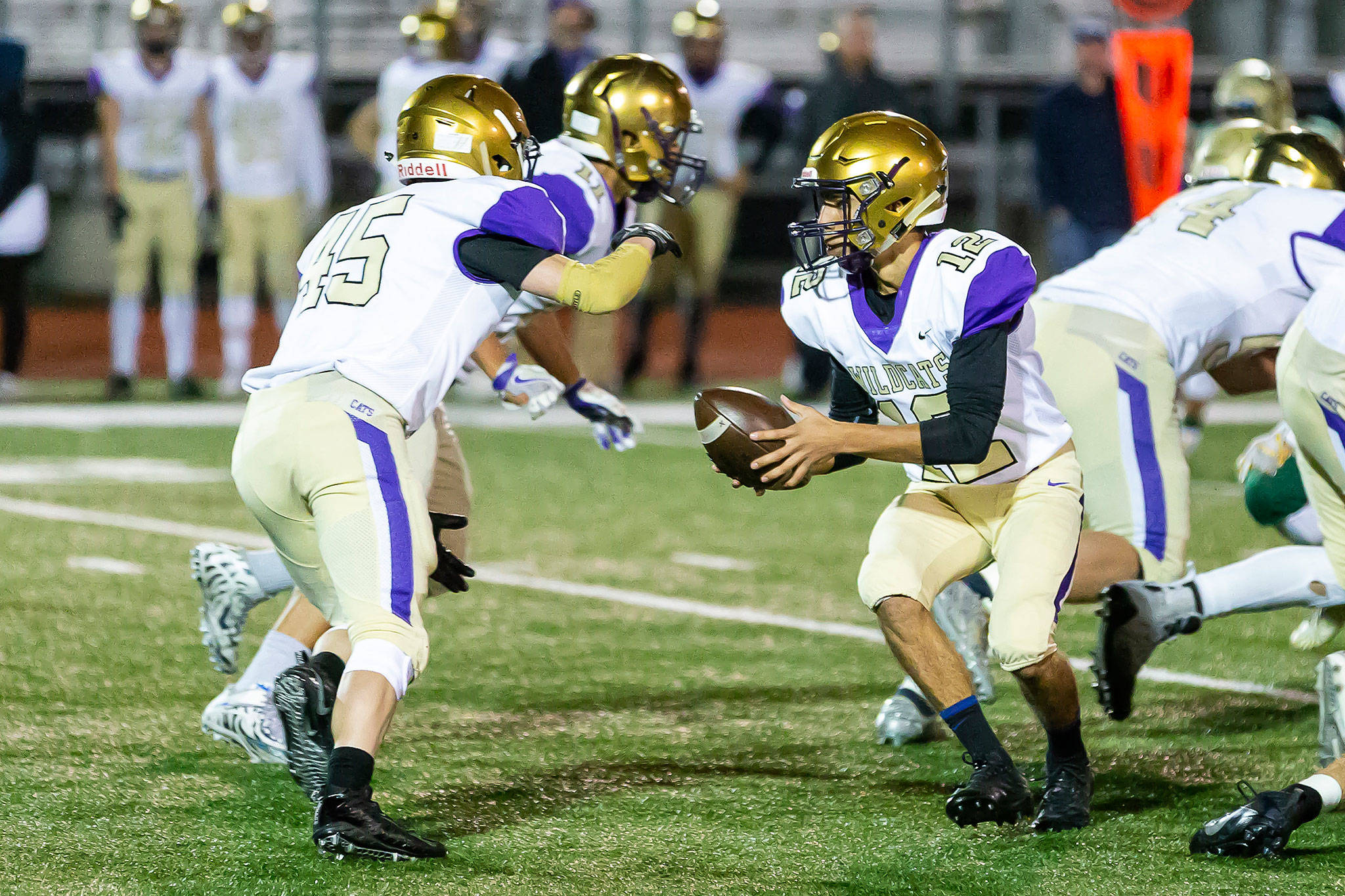Oak Harbor quarterback Caleb Fitzgerald hands off to running back Caden Leckelt in Fridays playoff game.(Photo by John Fisken)
