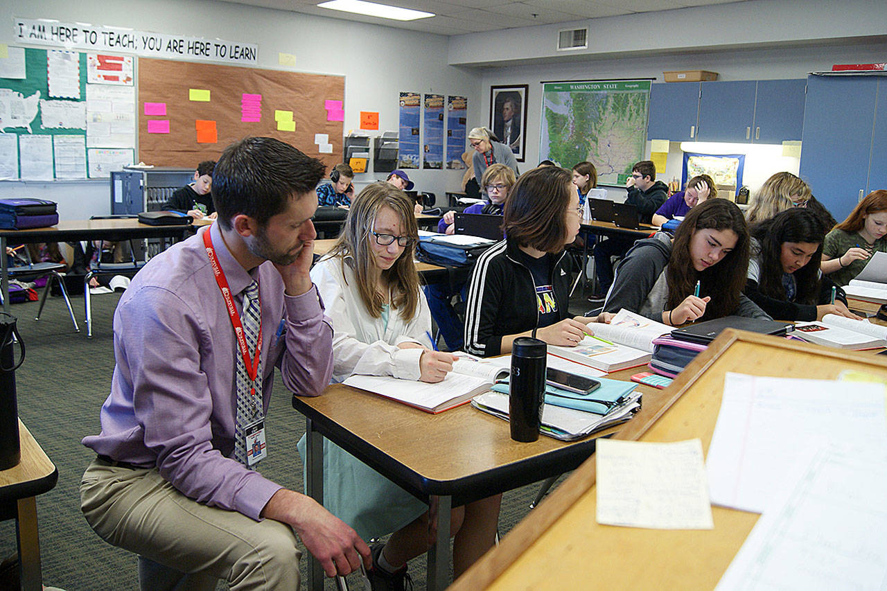 Photo by Maria Matson/Whidbey News-Times.                                Brandon Volkman, seventh- and eighth-grade teacher at Coupeville Middle School, assists students. A new program, Tutorial Time, is helping students to catch up in the classroom.