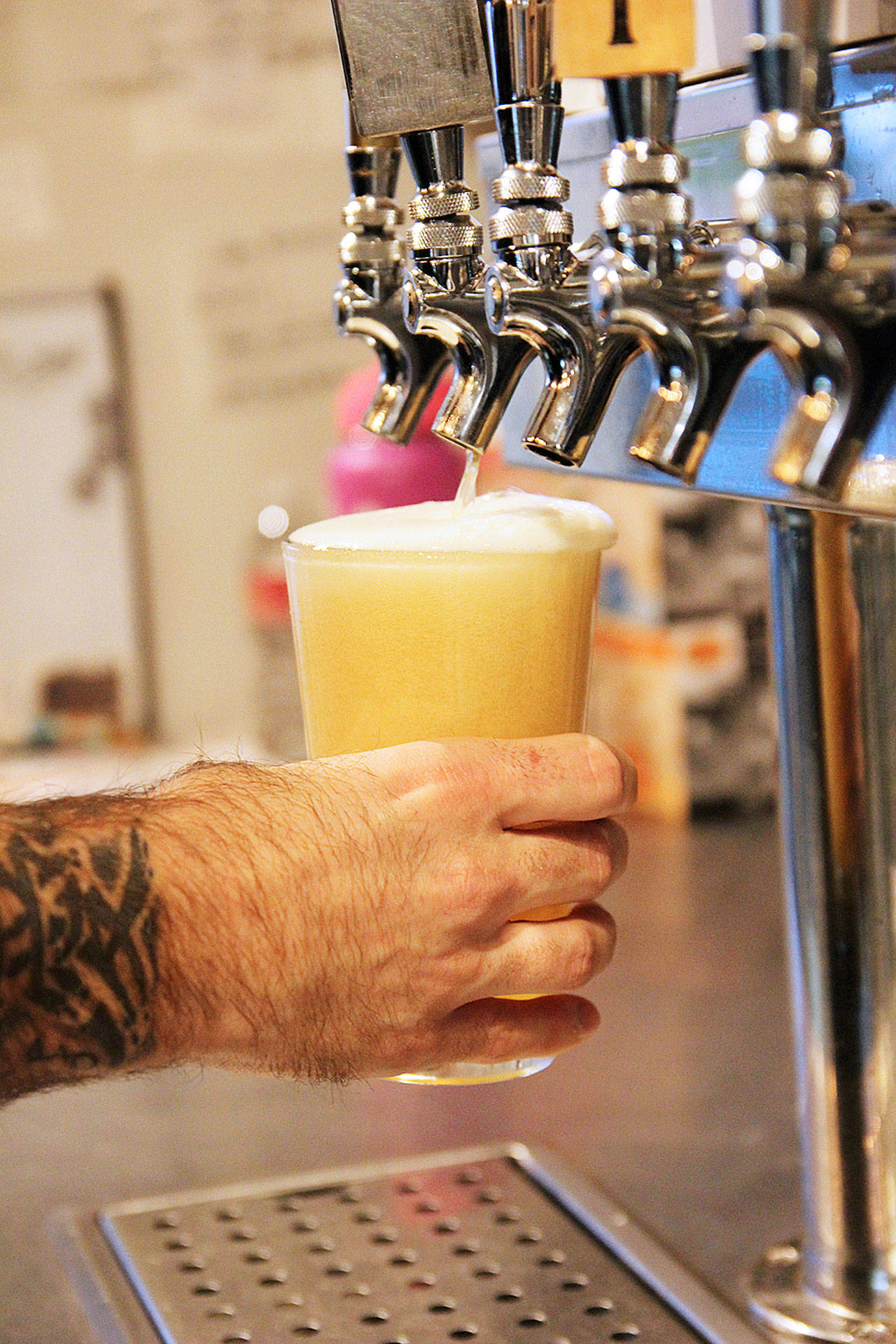 JJ Marti fills up a beer at Rock Island Coffee, which sells much more than just coffee. Photo by Laura Guido/Whidbey News-Times