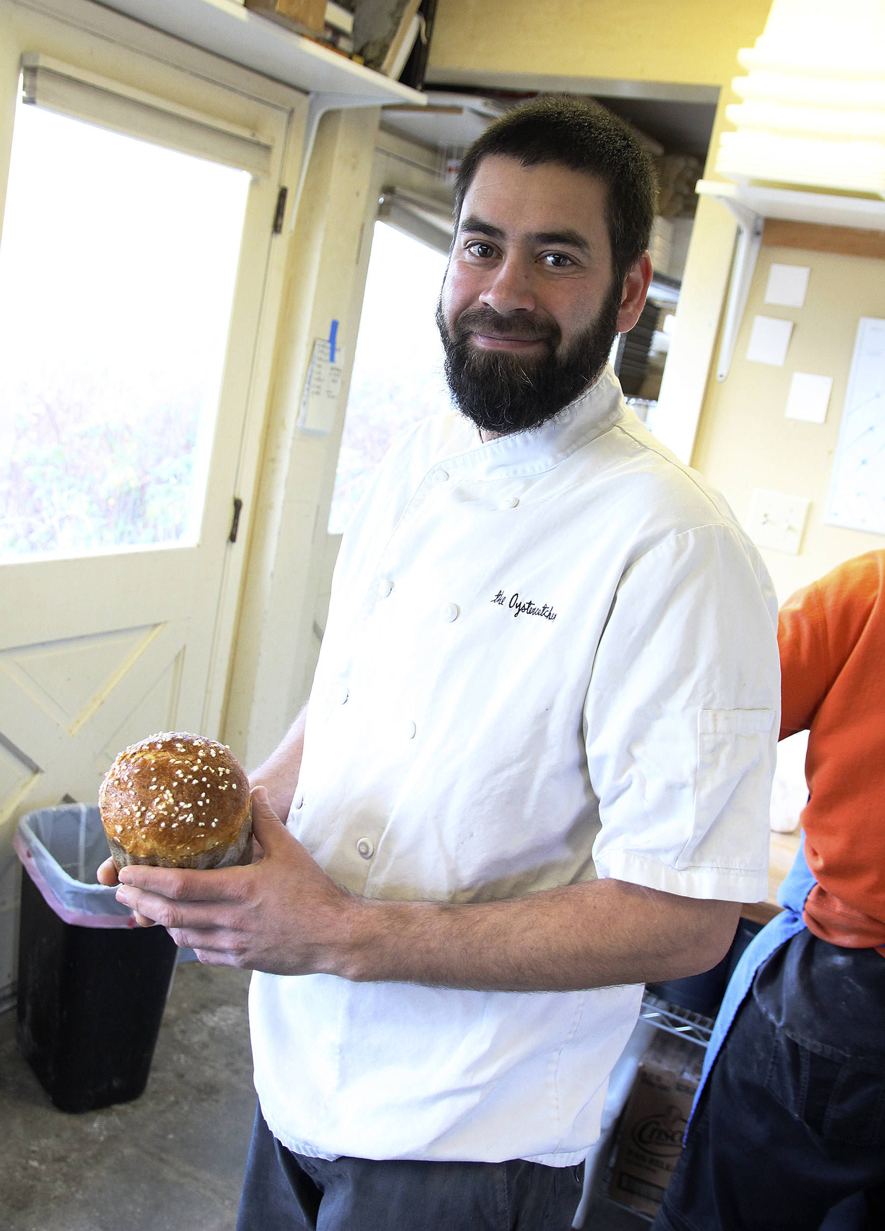 Chef and owner Tyler Hansen holds a loaf of the Oystercatcher’s holiday panettone— a light, fruity bread. (Photo by Laura Guido/Whidbey News Times)