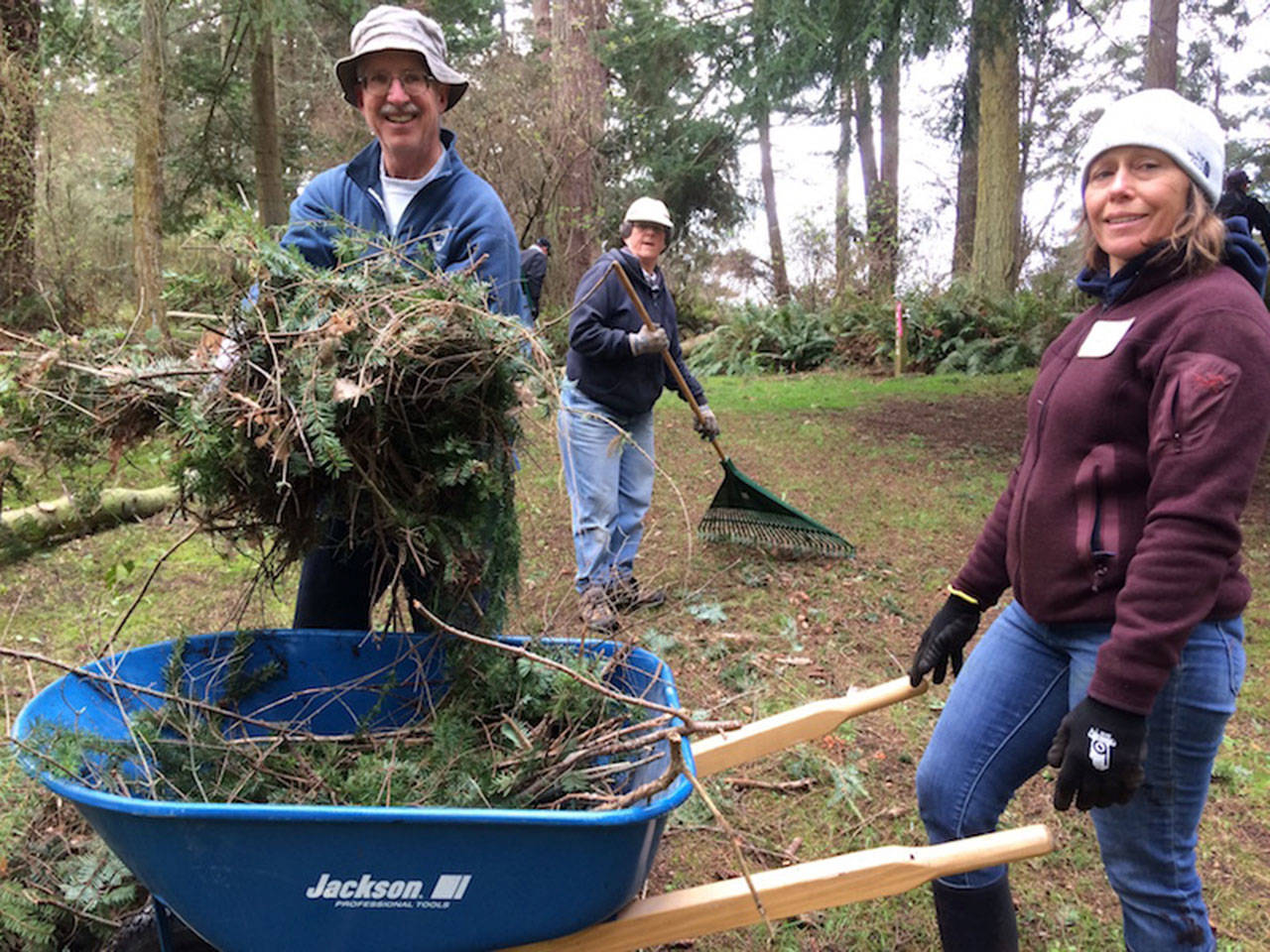 Friends of Whidbey State Parks volunteers Gary Ketcheson, left, Liz Ketcheson and Amy Bullis rake up branches at South Whidbey State Park. (Photo provided)